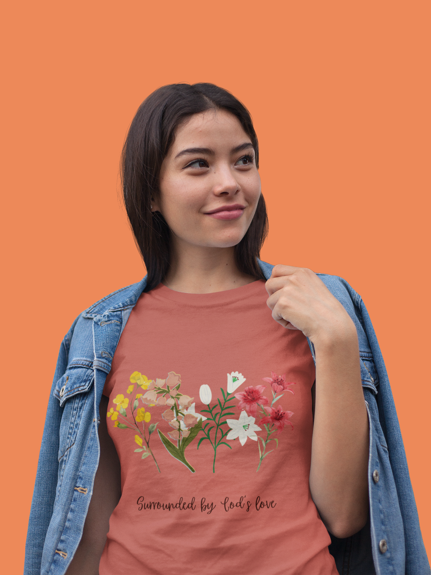 Woman wearing a pink t-shirt with floral design and text on an orange background